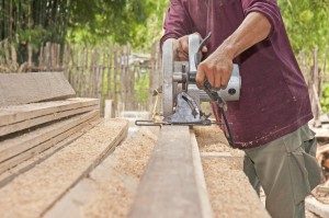 Mann sägt Holzbretter